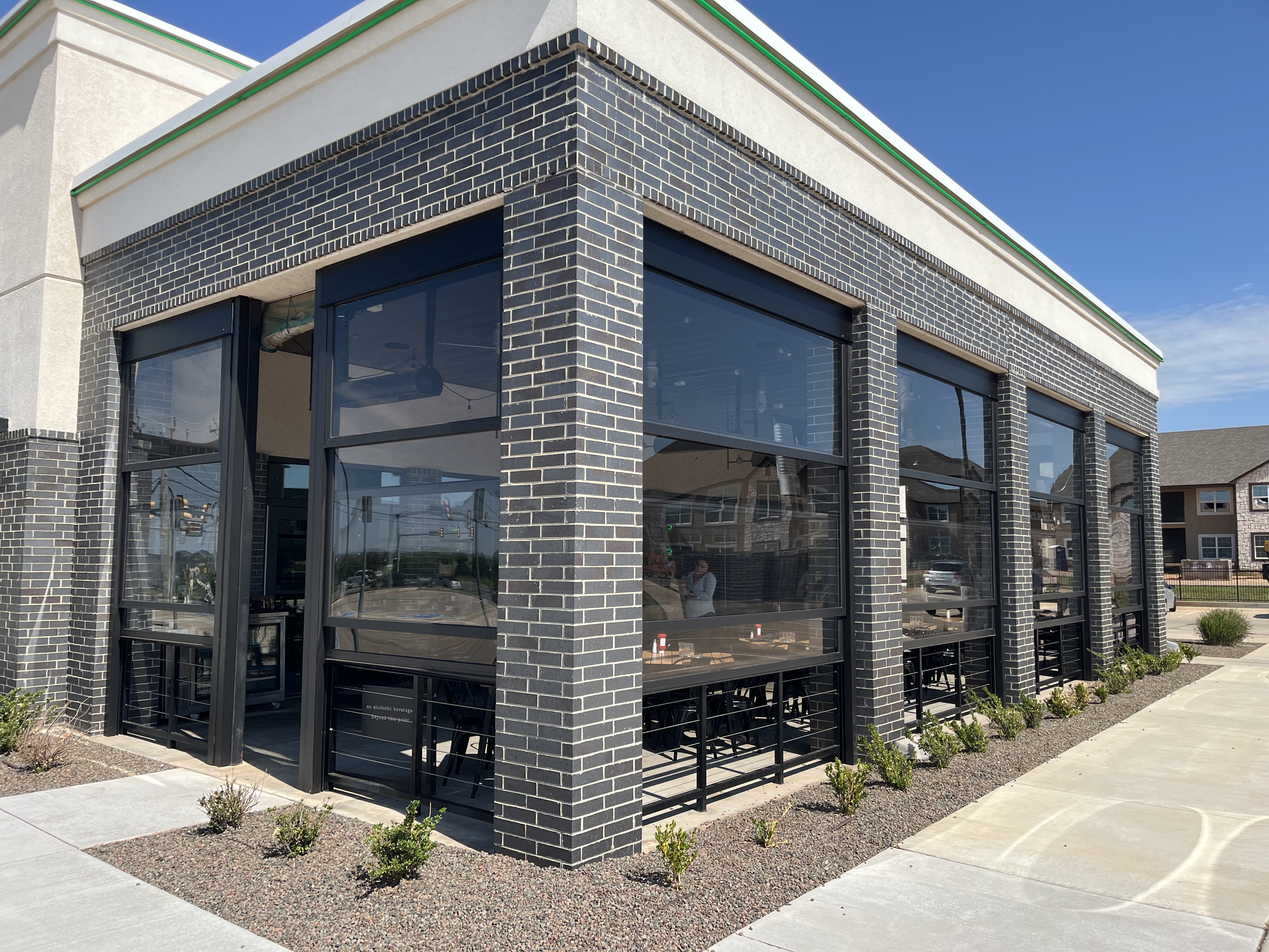 Stax motorized patio lift wall system installed on a covered patio